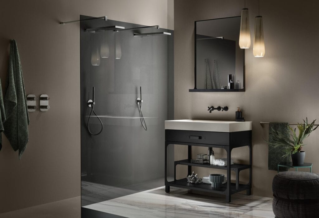 Modern bathroom with a glass-enclosed shower, floating vanity with a square sink, large mirror, hanging pendant lights, and decorative plants.