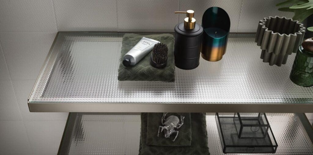 Decorative bathroom shelf with toiletries, including a lotion tube, brush, soap dispenser, candle holder, and ornate container.