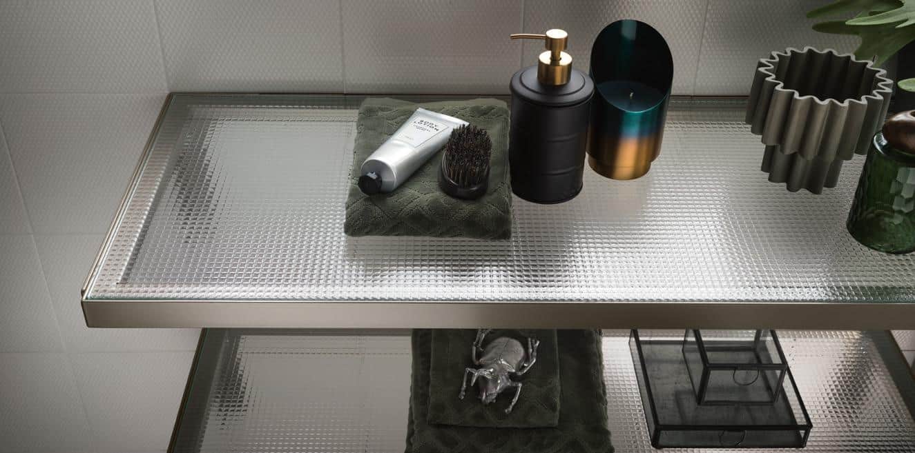 Decorative bathroom shelf with toiletries, including a lotion tube, brush, soap dispenser, candle holder, and ornate container.