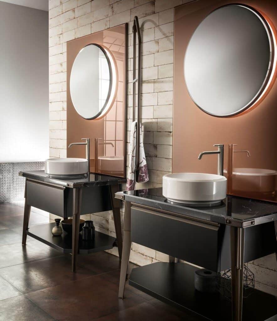 Double bathroom vanity with round mirrors, vessel sinks, and modern faucets, featuring a tiled wall backdrop.