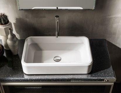 Rectangular white sink with a sleek faucet on a dark speckled countertop, next to decorative vases.