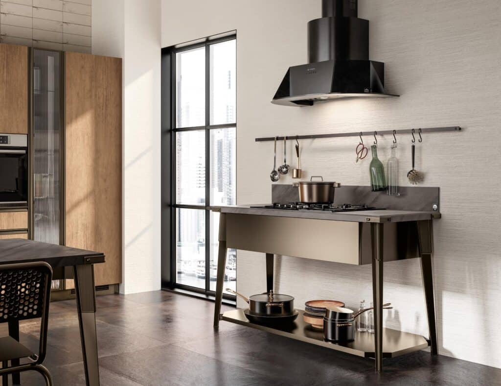 Modern kitchen interior with a black and wood finish, featuring a stove with hanging utensils and decorative bottles, set against a textured wall with large windows.