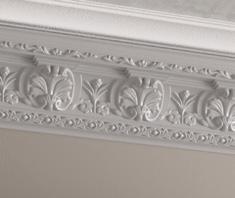 Ornate white plaster cornice with intricate floral designs.