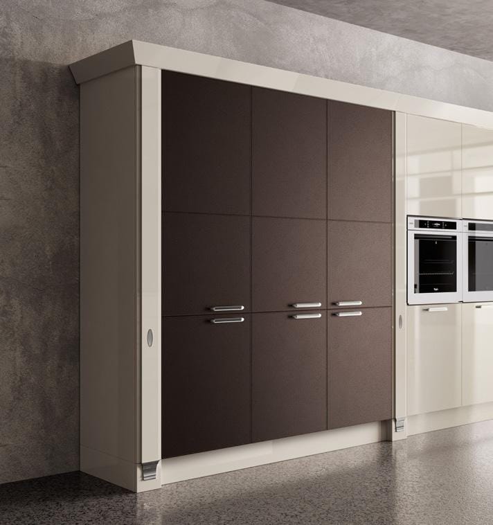 Dark brown kitchen cabinets with silver handles on a modern wall unit, adjacent to white cabinets featuring built-in ovens.