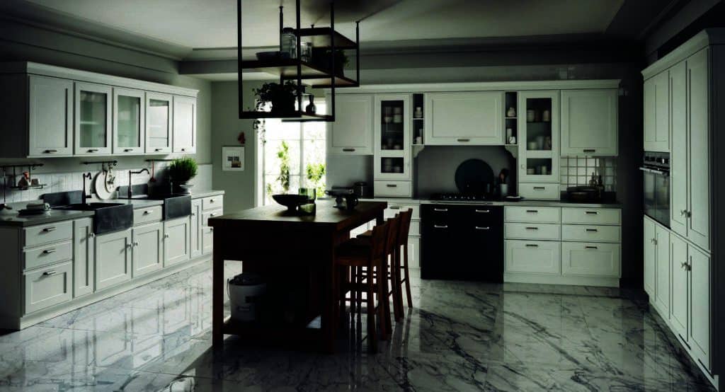 Modern kitchen with white cabinets, a wooden island, marble floor, and hanging shelves with plants.