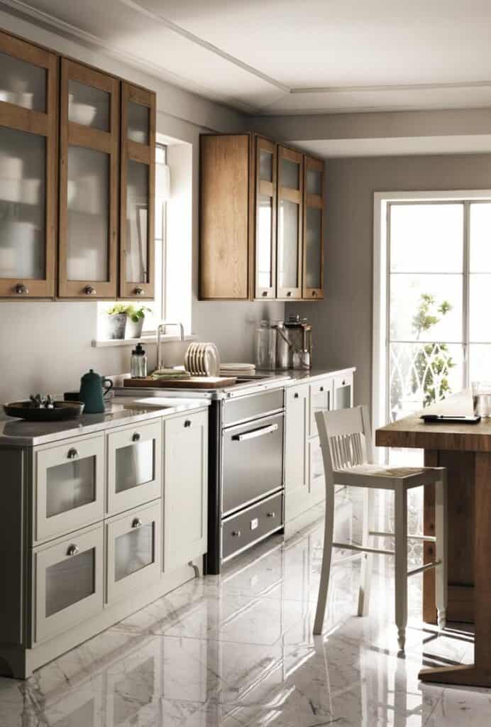 Modern kitchen with wooden cabinets, stainless steel appliances, and marble flooring.