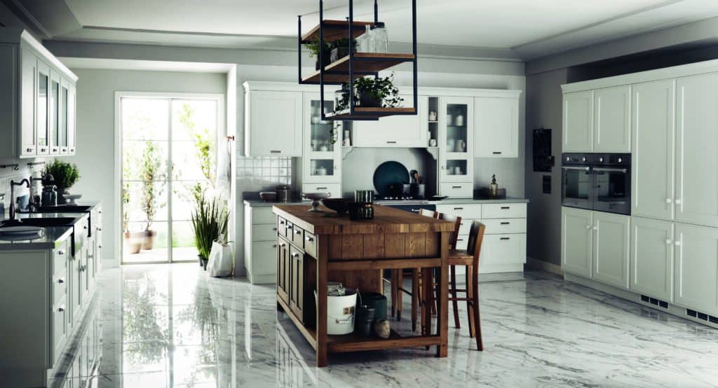 Modern kitchen with white cabinets, a wooden island, hanging shelving, and marble floor.