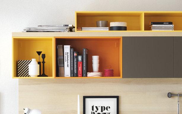 Yellow wall-mounted shelves with books, decor items, and open compartments.