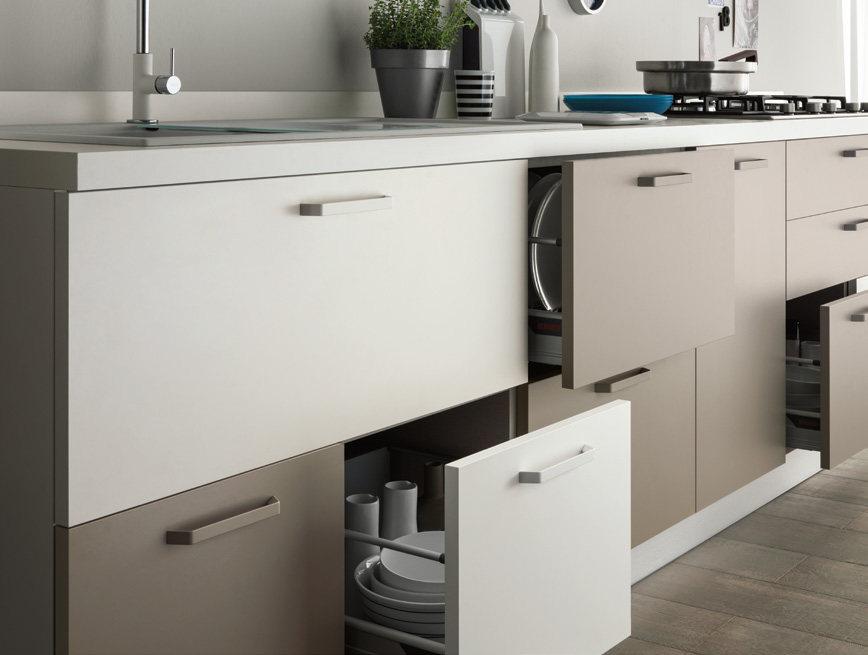 Modern kitchen cabinets with open drawers and visible dishes inside.