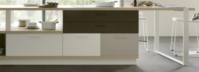 Modern kitchen island with drawers and shelves, featuring neutral-toned cabinetry and a white countertop.
