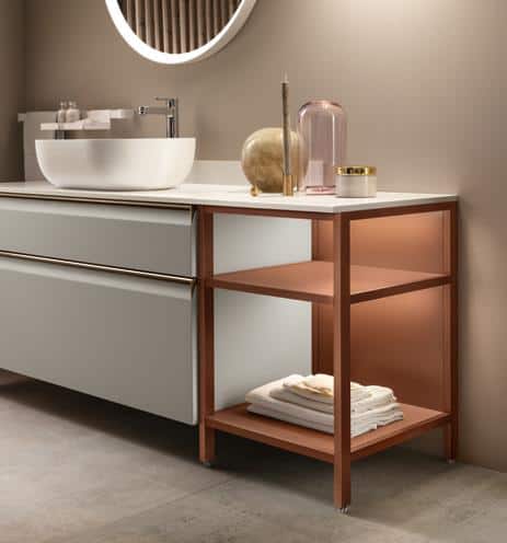 Modern bathroom vanity with a round mirror, white countertop, bowl sink, and a copper-colored shelving unit below.
