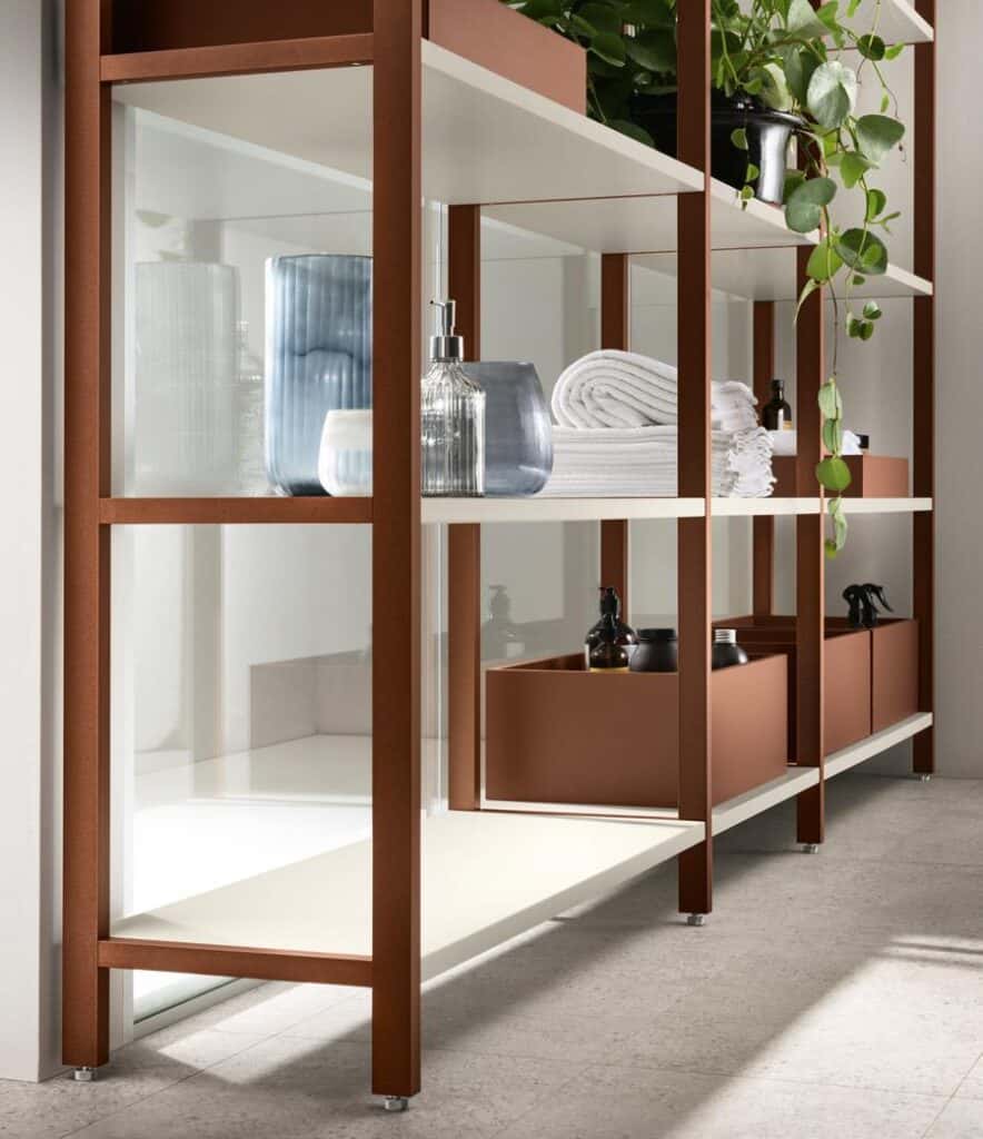 Modern shelving unit with glass and metal features, holding decorative vases, towels, plants, and various containers.