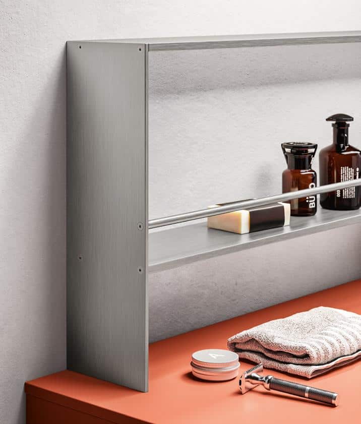 A modern bathroom shelf with grooming products, a razor, and folded towels on a countertop.