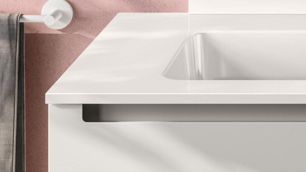Close-up of a modern white bathroom vanity and sink with a towel hanging on the left.