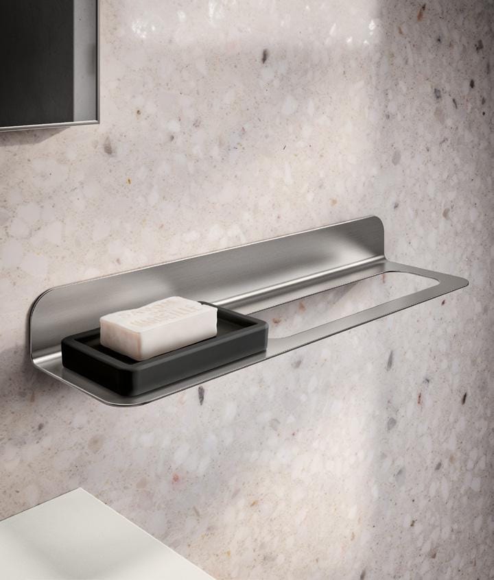 A soap holder mounted on a bathroom wall, holding a bar of soap.