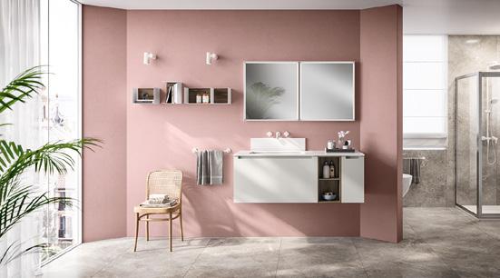 Modern bathroom interior with a pink wall, floating vanity, dual mirrors, wooden chair, shelves, and a glass shower.