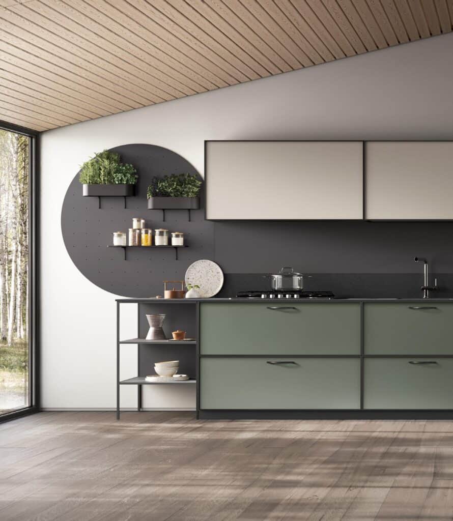 Modern kitchen interior with gray and green cabinets, circular wall shelves, and large windows showing trees outside.