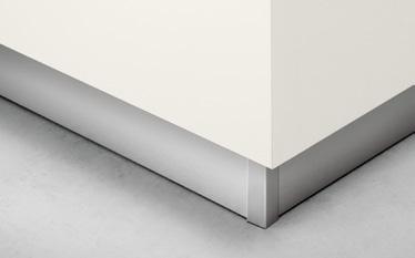 Corner of a wall with a gray metallic baseboard trim.