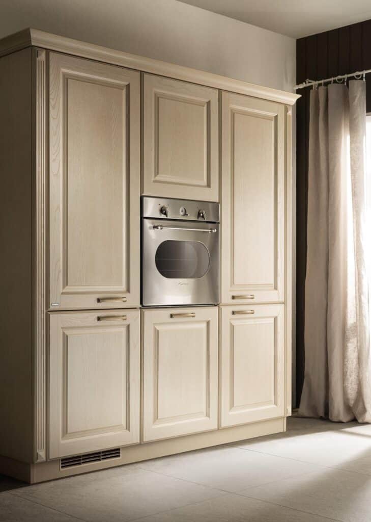 A kitchen with light wood cabinetry and a built-in stainless steel oven.