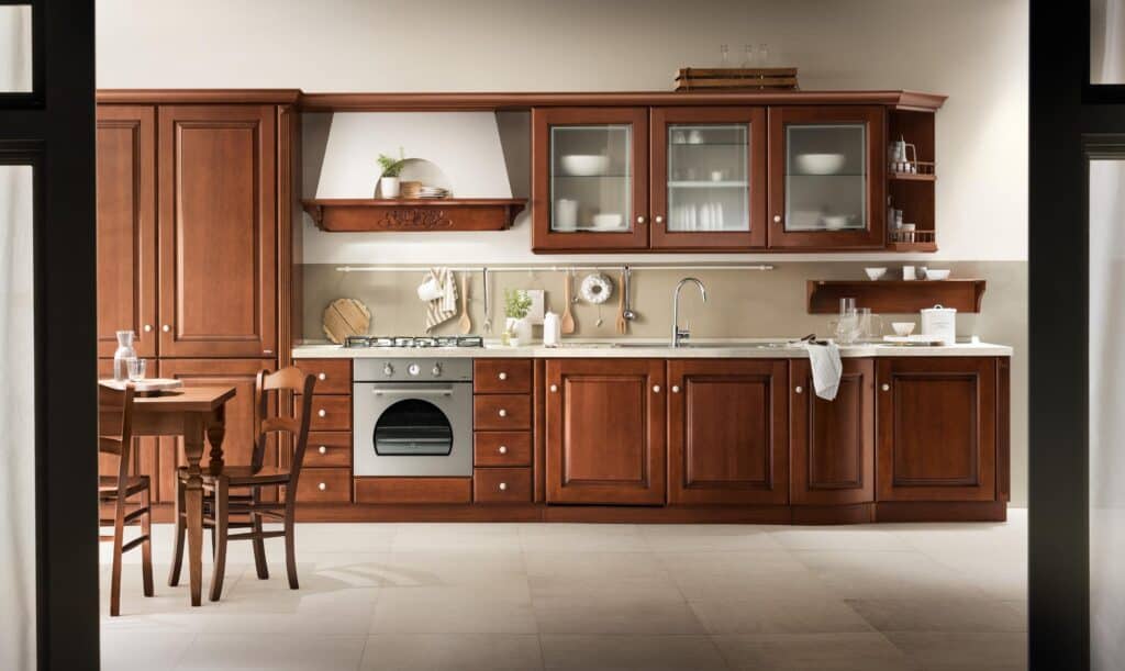 Traditional kitchen with wooden cabinets, a gas stove, and a dining table with chairs.