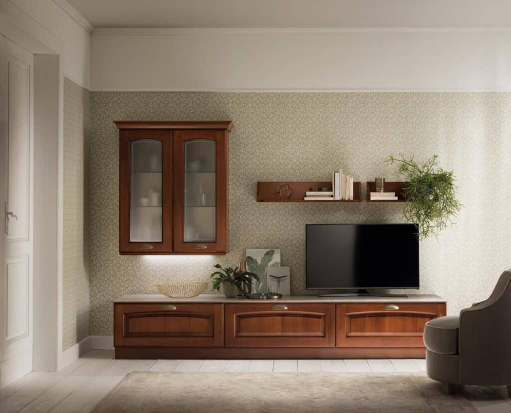 Living room with wooden furniture, including a wall cabinet, shelves with books and plants, a TV stand, and a TV.