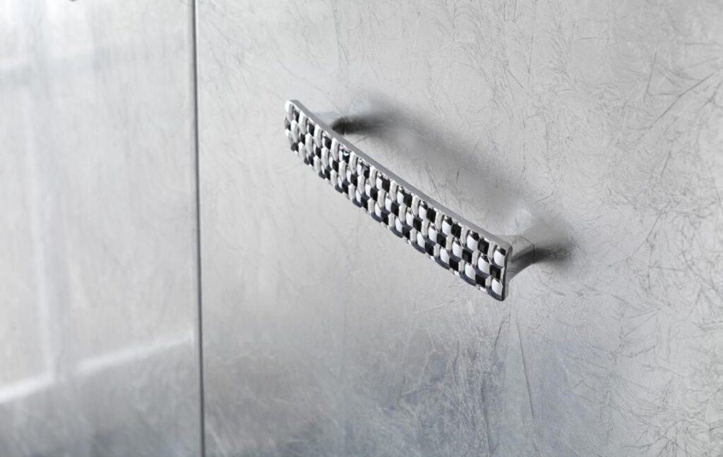Metallic textured surface with a modern metal handle attached.