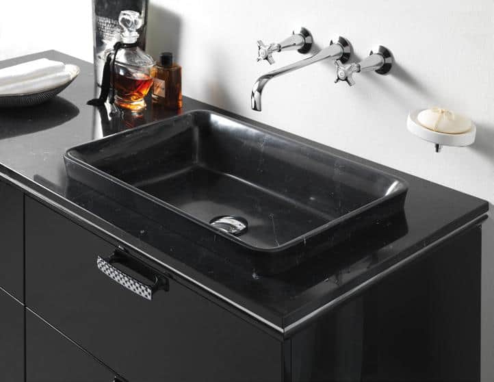 Black marble sink with chrome faucet fixtures and a black vanity.