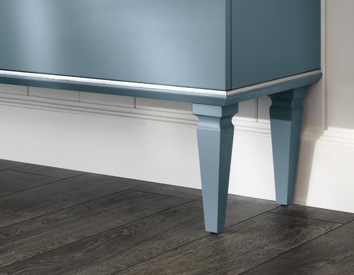 Blue cabinet with tapered legs on dark wood flooring against a white wall.