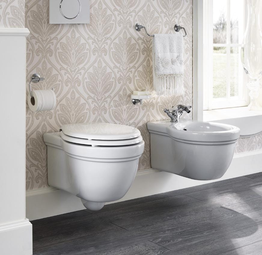 Modern bathroom with a wall-mounted toilet and bidet, grey patterned wallpaper, and a towel rack above the bidet.