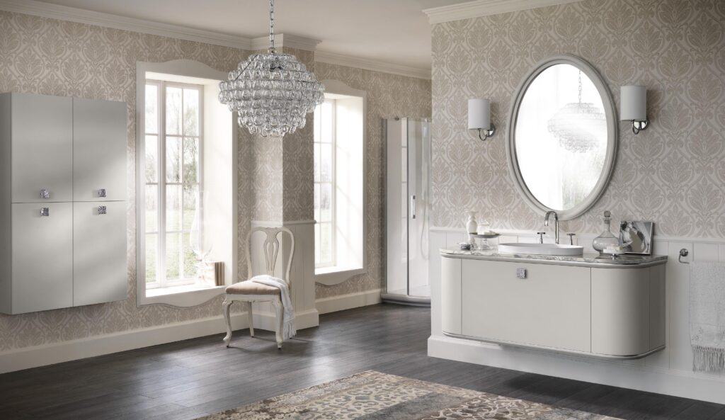 Elegant bathroom with vintage wallpaper, chandelier, oval mirror, curtain style vanity, dark wood flooring, and a light patterned rug.