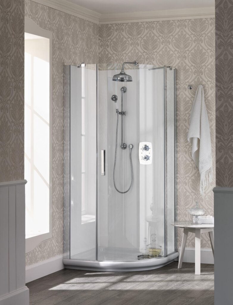 A modern glass shower enclosure with a rain shower head and handheld shower set, set in a bathroom with patterned wallpaper and a wooden floor.