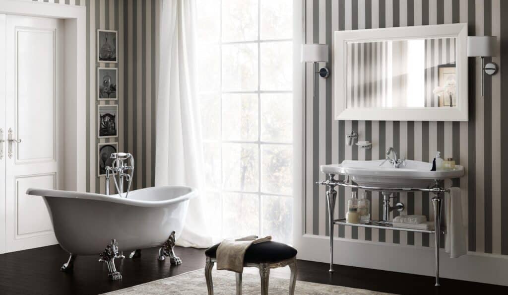 Elegant bathroom with a clawfoot bathtub, striped wallpaper, and a large window.