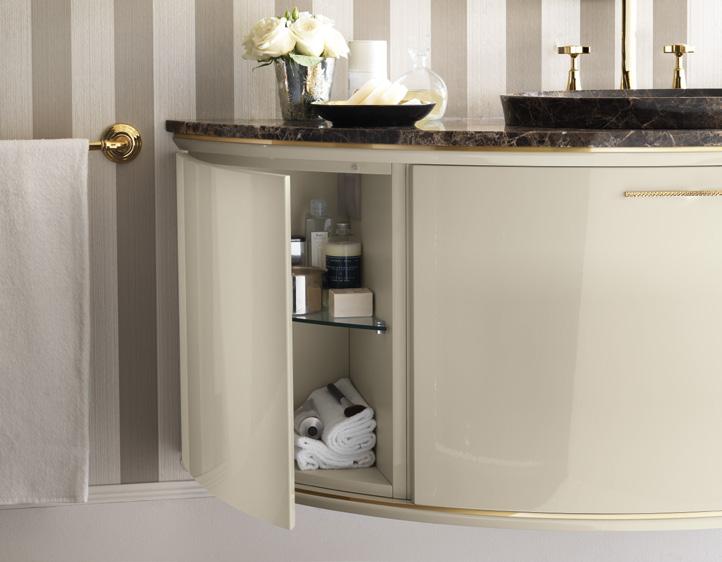 A beige bathroom cabinet with open door, showing towels and toiletries inside, topped with a marble countertop, sink, and decorative items.
