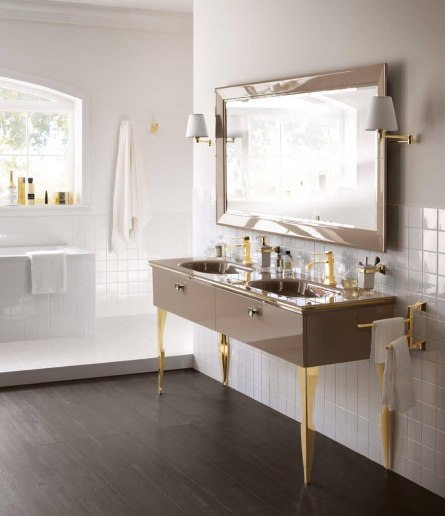 Luxurious bathroom with a double sink vanity featuring gold accents, a large mirror with side lamps, and a window providing natural light.