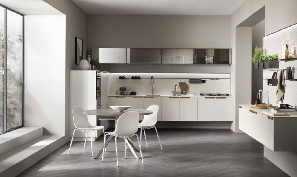 Modern kitchen with sleek cabinets, a round dining table with four white chairs, and large windows letting in natural light.