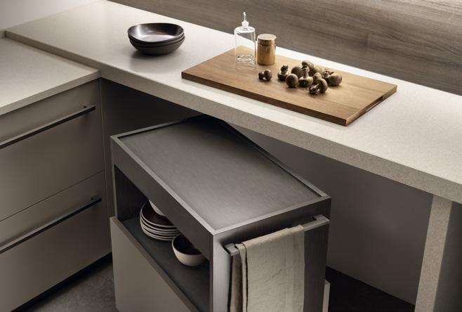 Modern kitchen countertop with drawers, a cutting board with mushrooms, a small jar, and a bowl.