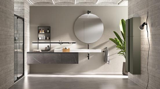 Modern bathroom with a large circular mirror, floating vanity, open shelving, and a potted plant.