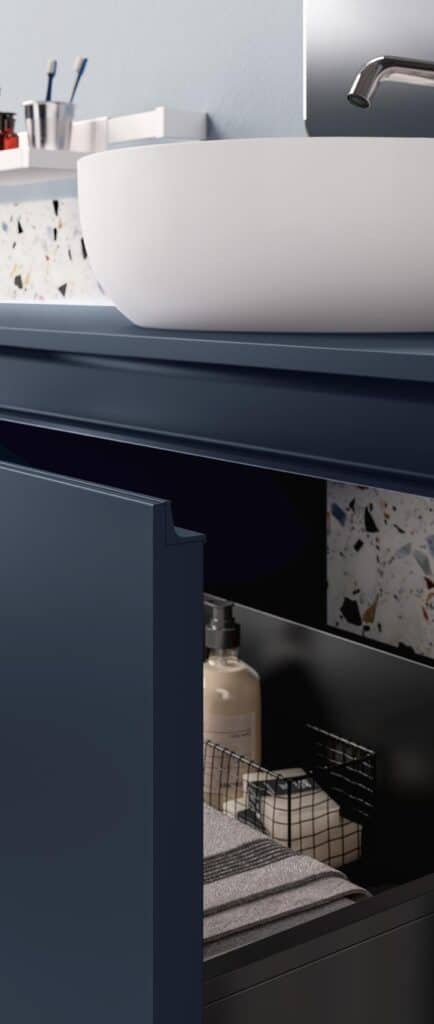 Modern bathroom vanity with a curved white basin on top, a blue open cabinet below with toiletries, and a metal faucet to the side.