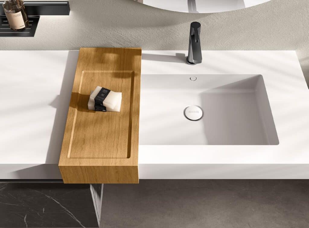 Modern bathroom sink with a wooden soap tray and a black faucet.