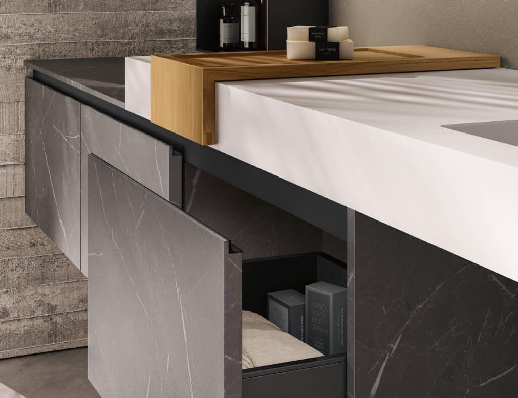Modern bathroom vanity with concrete-like cabinets, a white countertop, wooden tray, and cosmetics.