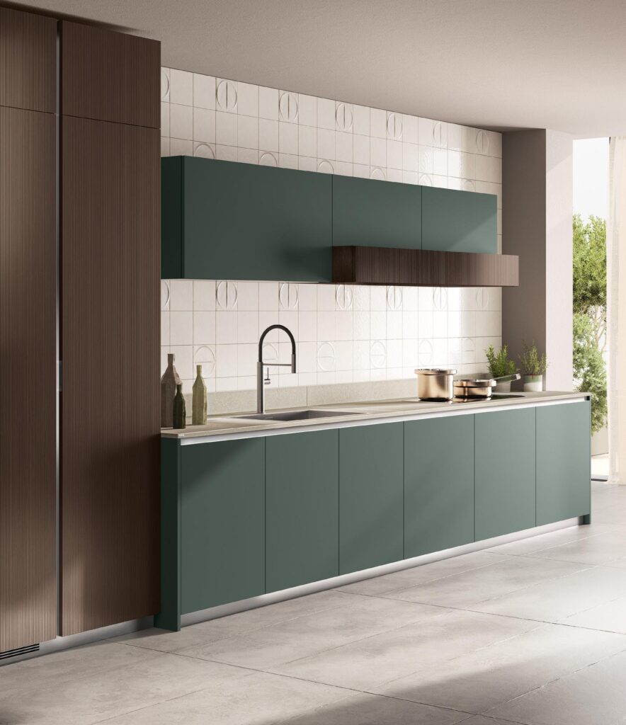 Modern kitchen with matte green cabinets, minimalist faucet, geometric wall tiles, and wooden accents.