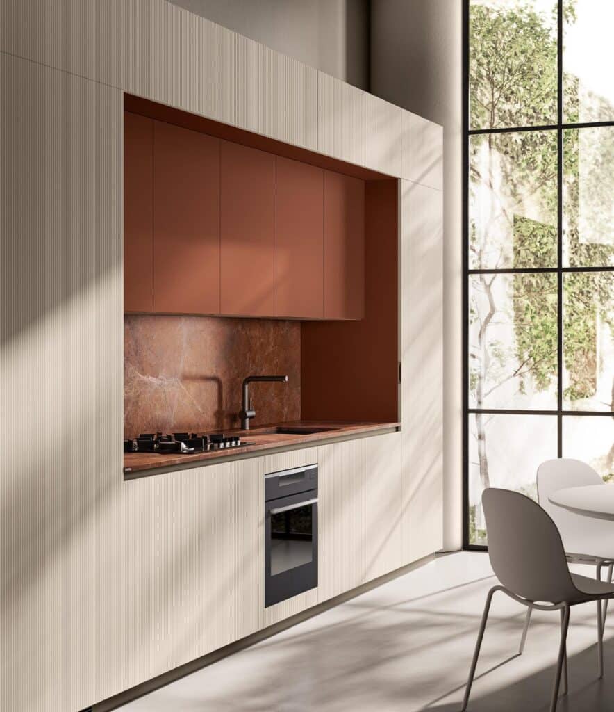 Modern kitchen with integrated beige cabinets, rust-colored backsplash, built-in appliances, and a large window overlooking greenery.