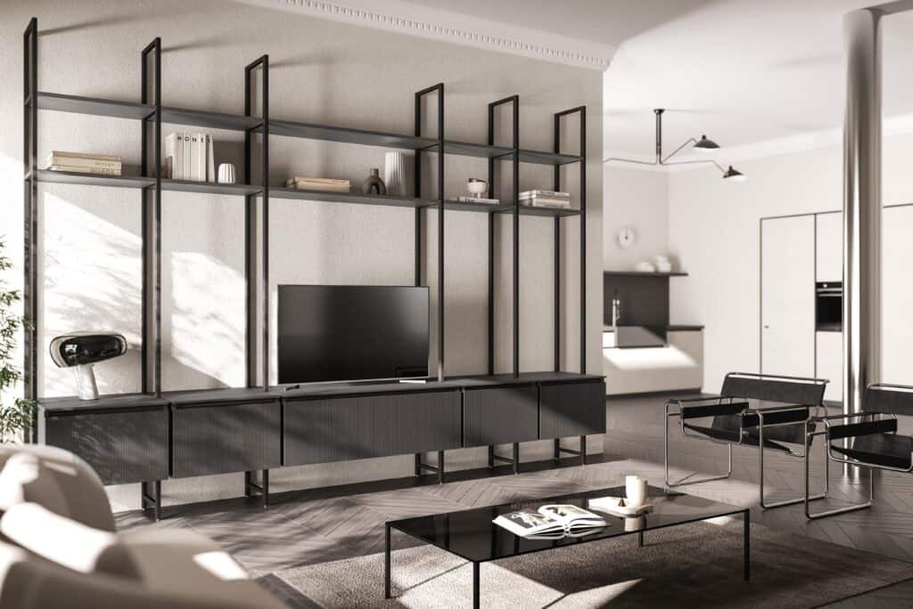 Modern living room with a minimalist design featuring a black shelving unit with a flat-screen TV, books, and decor items. Two black chairs and a glass coffee table with a book and candle are in the foreground.