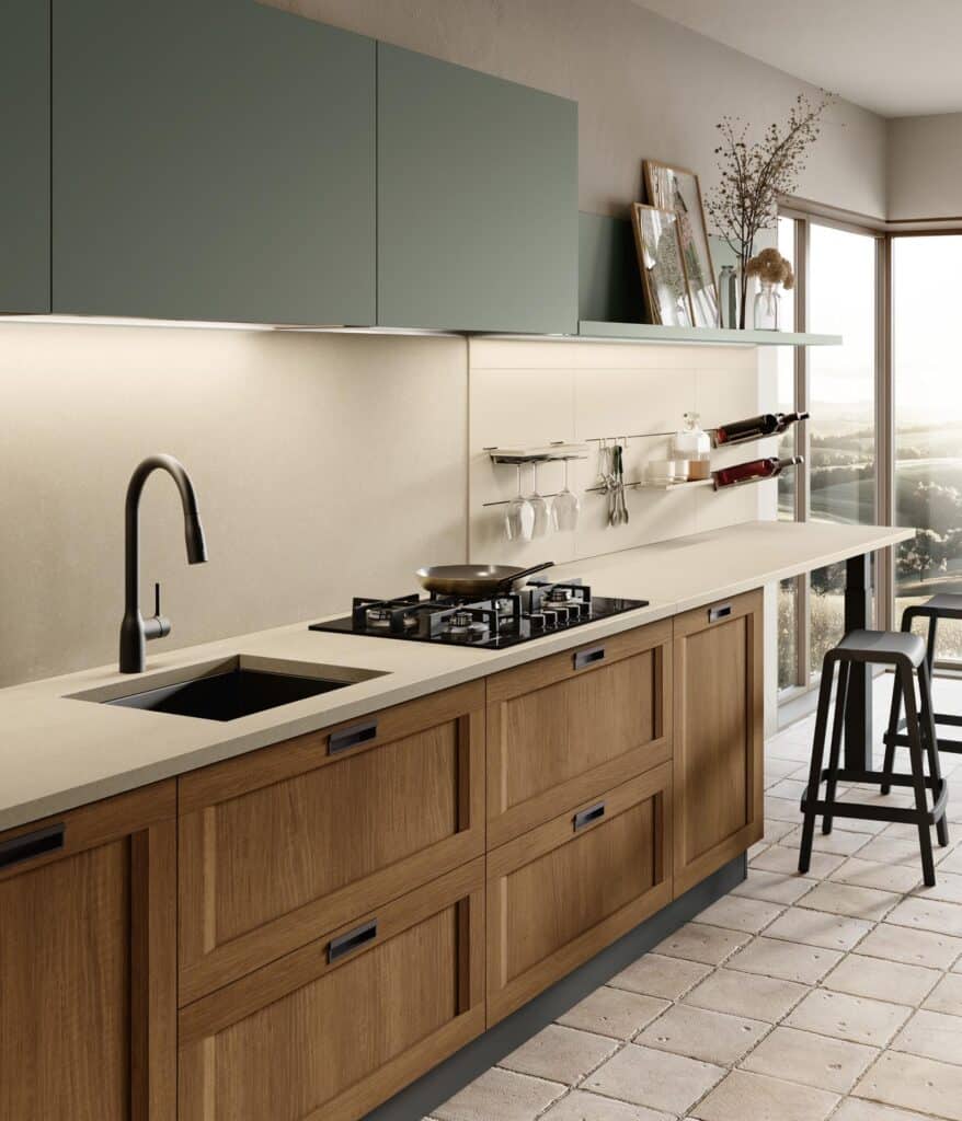 Modern kitchen with wooden cabinets, beige countertop, black faucet, gas stove, and bar stools by a window.