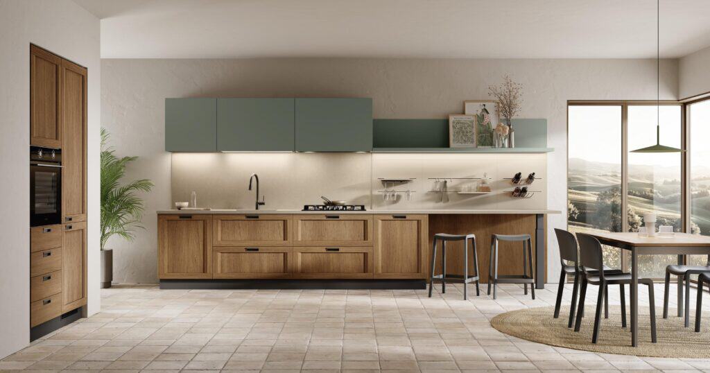 Modern kitchen with wooden cabinets, green upper units, a dining table, and large windows overlooking a scenic landscape.