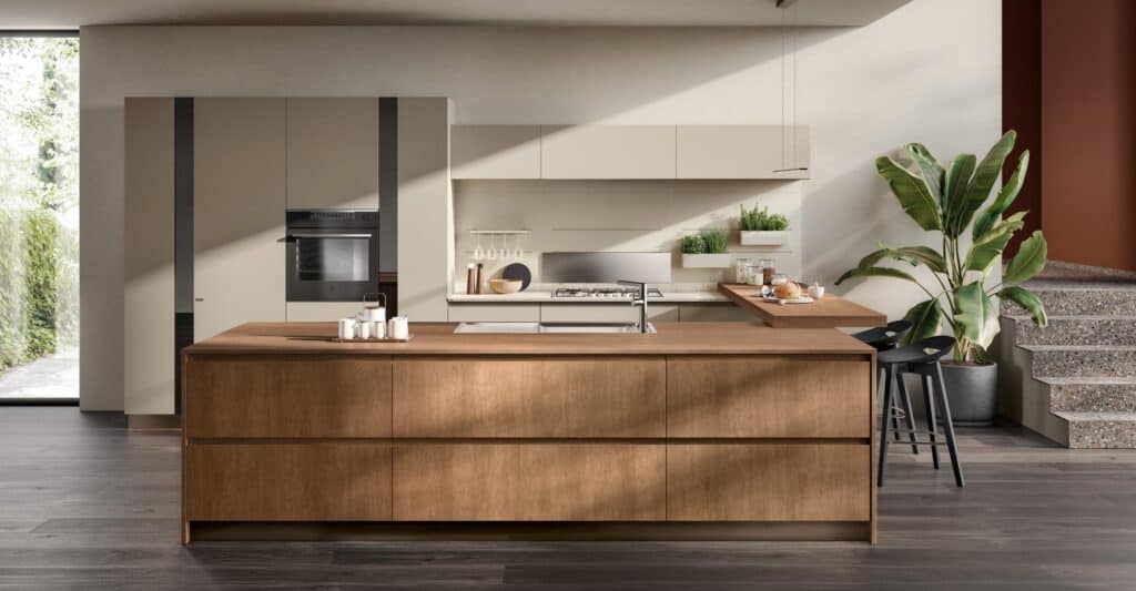 Modern kitchen with a large wooden island, built-in appliances, light-colored cabinets, and potted plants.