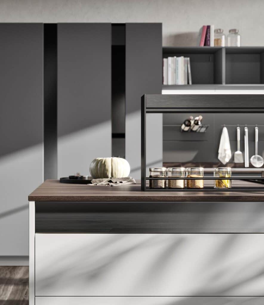 Modern kitchen interior with a dark countertop, spice jars, a pumpkin, and hanging utensils on the wall.