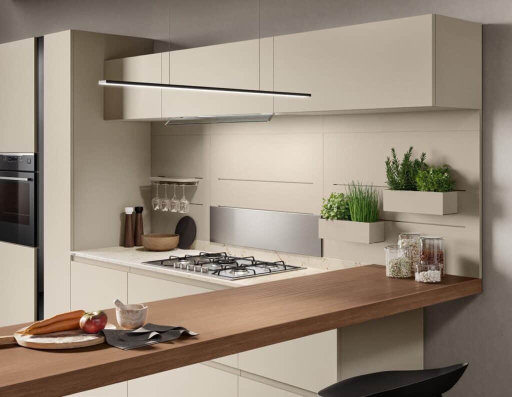 Modern kitchen with cream cabinets, a built-in oven, herbs in wall planters, a gas stove with a marble countertop, wooden utensils, and glass jars.