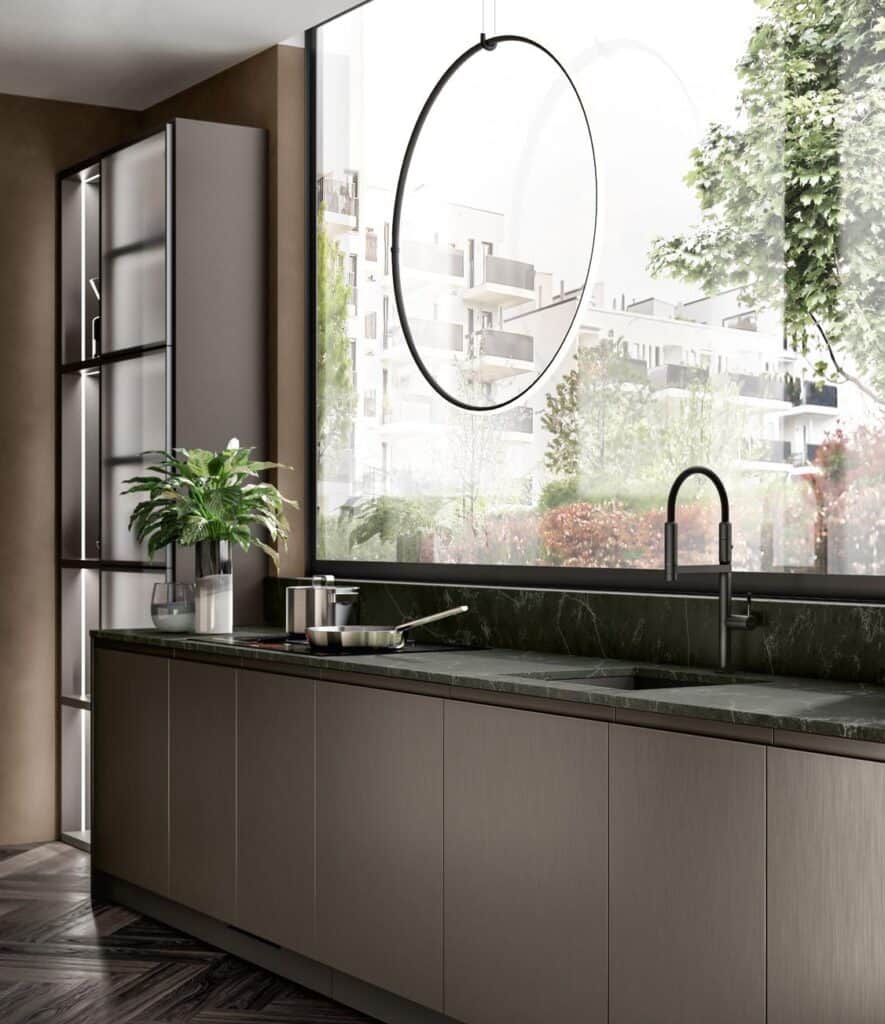 Modern kitchen interior with sleek cabinetry, large window overlooking urban greenery, and a minimalist black faucet on a dark countertop.