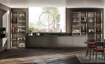 Modern kitchen with sleek cabinetry, herringbone wood flooring, open shelves, and a large circular window.